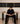 Person wearing black pants and top sitting on a table 