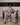 Person wearing grey sweatpants sitting on a chair looking with WE ARE GODS DAILY UNIT in the background